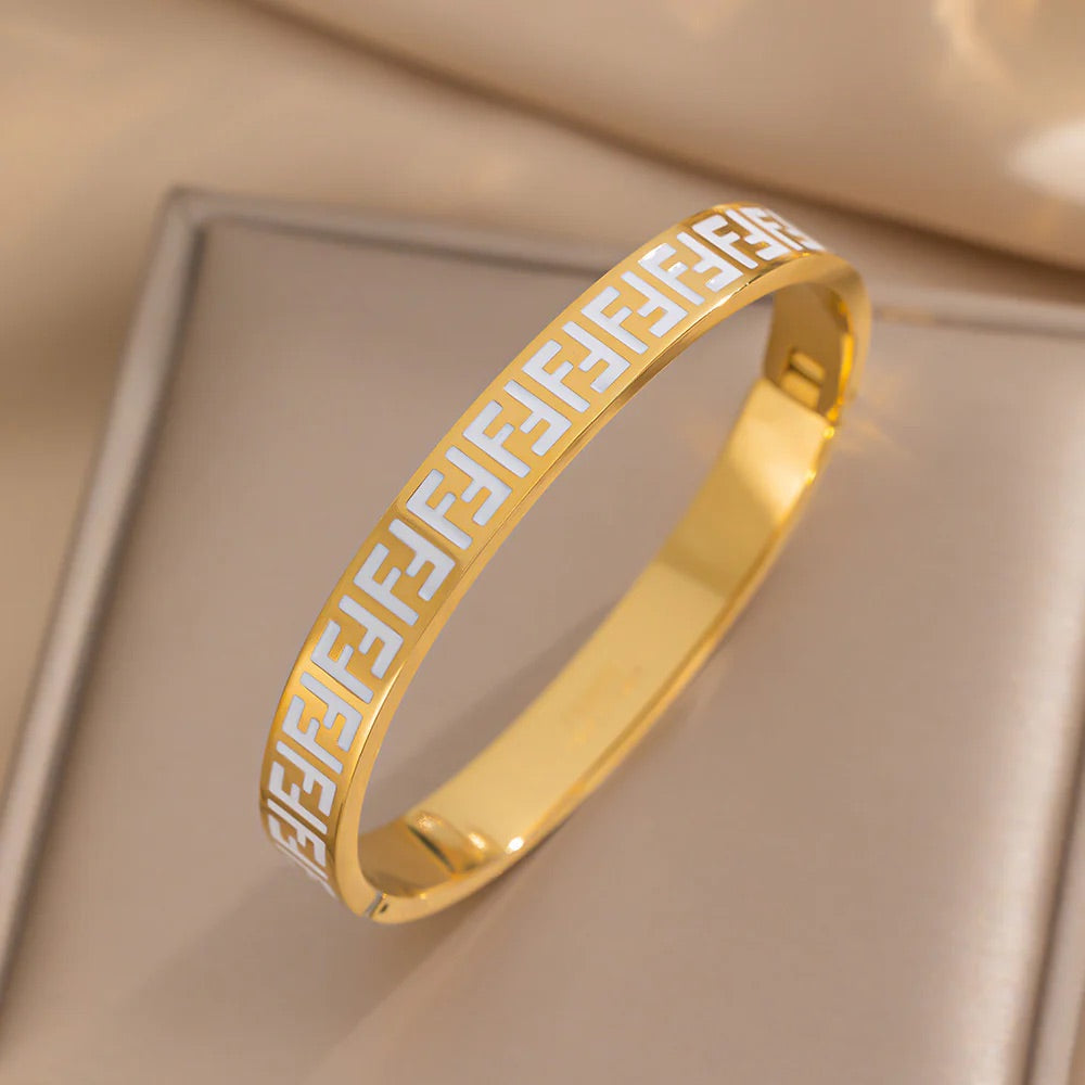 Close-up of gold enamel pattern bangle bracelet with star accent