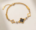 Gold bracelet with black and white clover charms