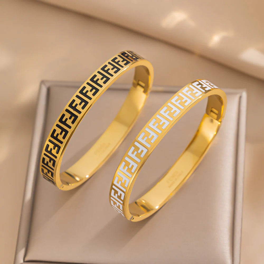 Gold and black enamel pattern bangle bracelets shown together