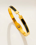 Gold cuff bracelet with H-style enamel inlay